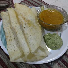 A picture of Sambhar dosa with chutney.
