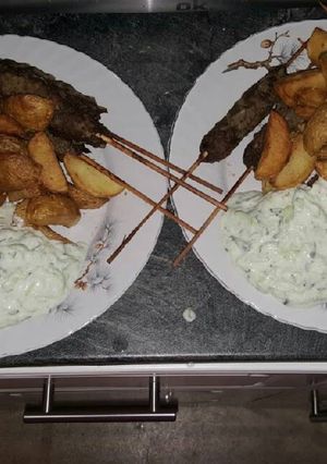 A picture of Grilled Kofta with Potatoes and Tzatziki Sauce.