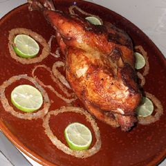 A picture of Stuffed chicken with macaroni and onion rings.