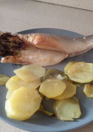 Una foto de Lubina en cama de patata, cebolla y pimiento