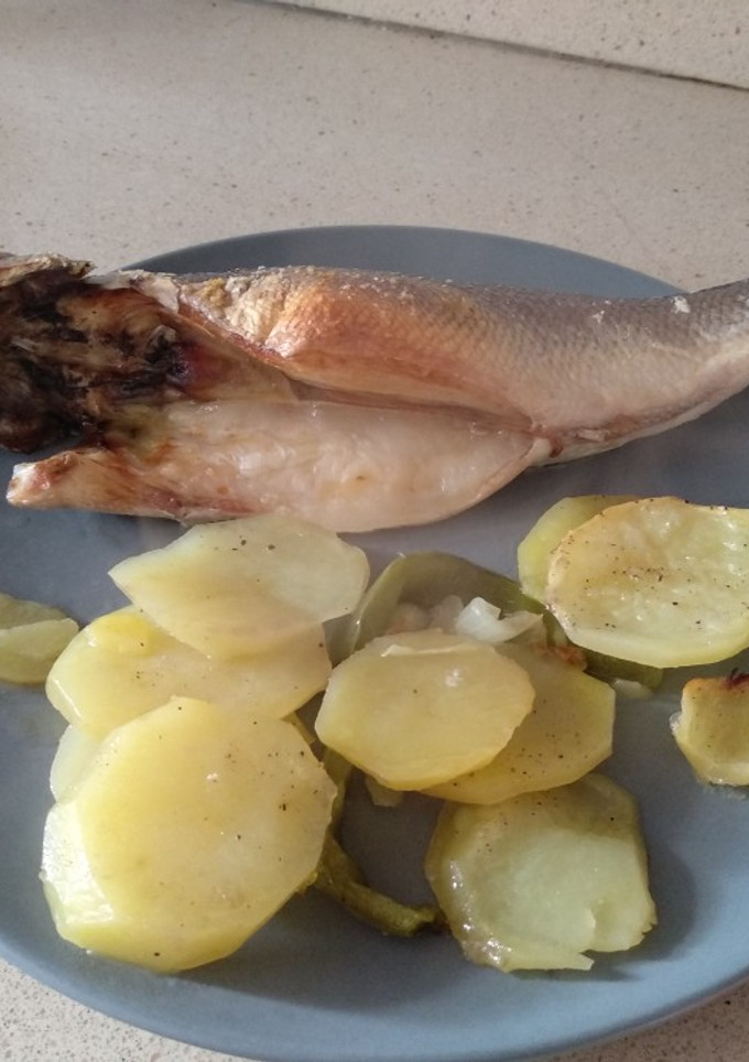 Una foto de Lubina en cama de patata, cebolla y pimiento