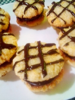 Una foto de Alfajores con masa de coco relleno de frosting de chocolate