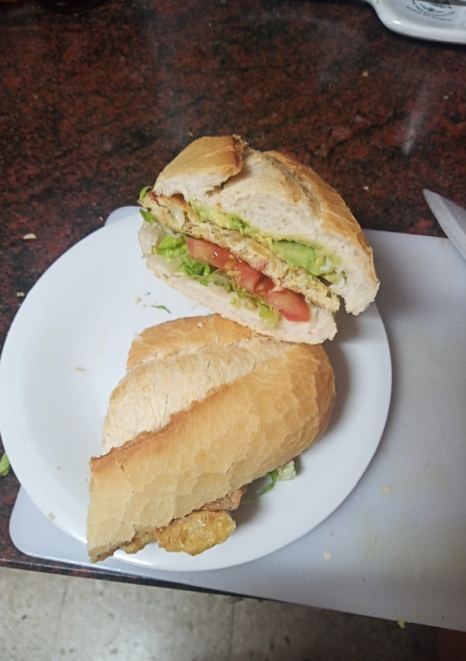 Una foto de Bocadillo de tortilla vaga de papas de paquete y jamón serrano con lechuga, tomate y aguacate