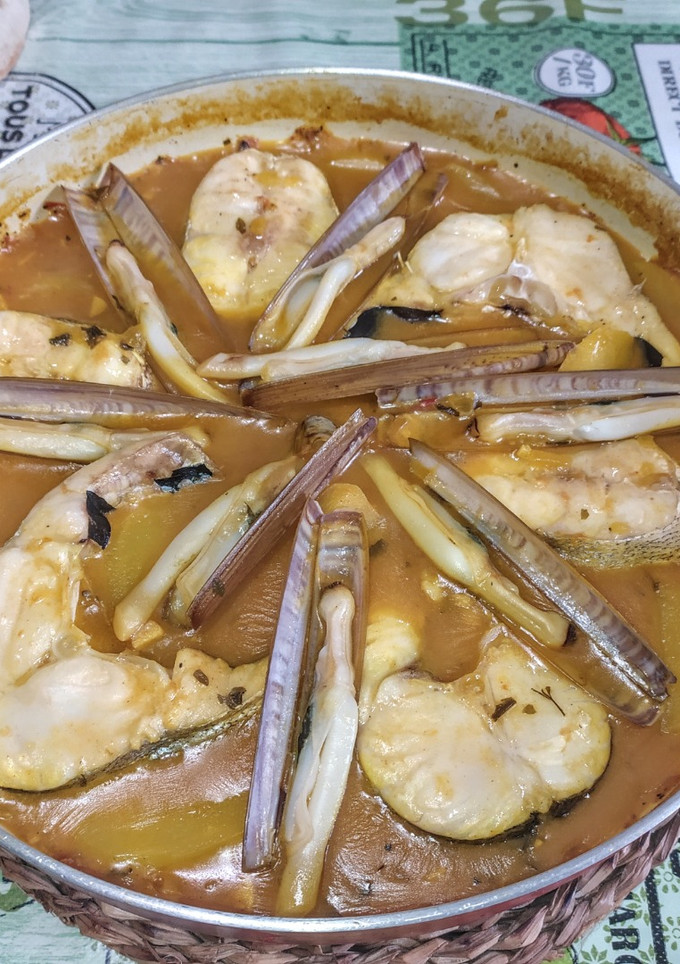 Una foto de Merluza con navajas en salsa marinera
