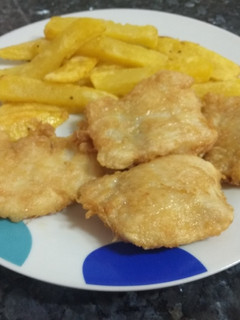 Una foto de Merluza albardada con patatas fritas