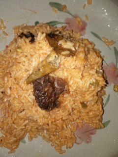 A picture of Jollof rice and fried meat.