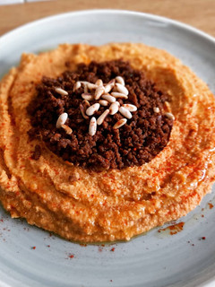 Una foto de Hummus a la sobrasada con carne especiada y piñones