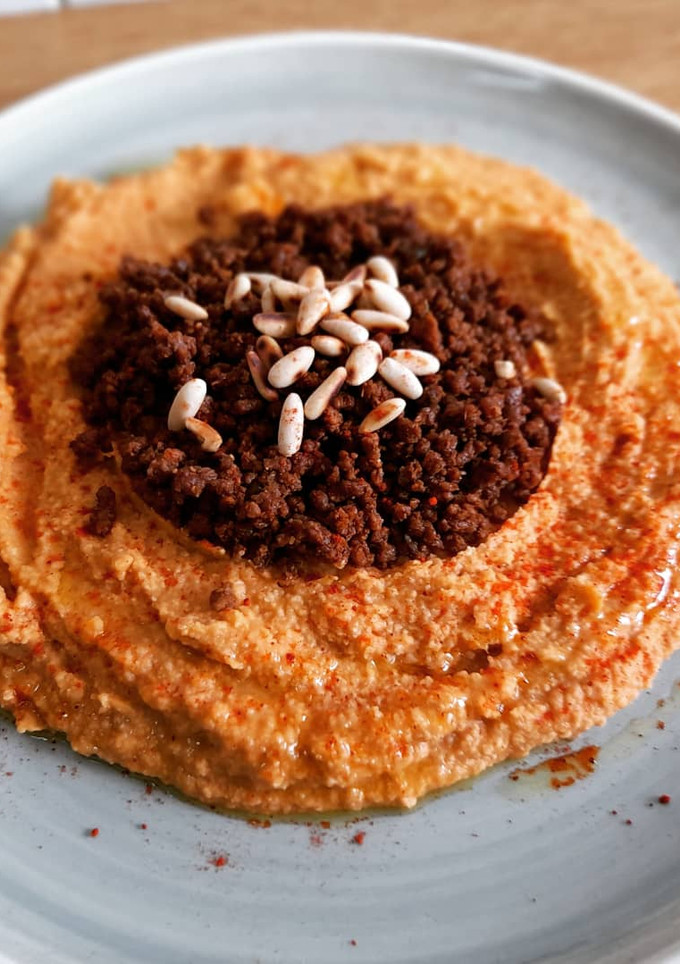 Una foto de Hummus a la sobrasada con carne especiada y piñones