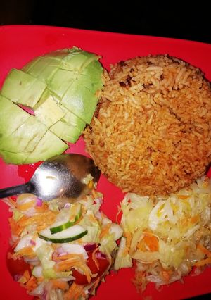 A picture of Pilau served with cabbage and salad.