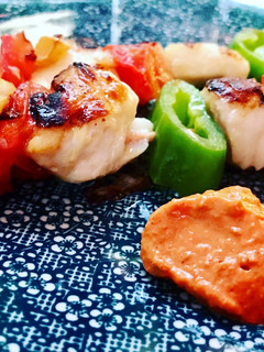 Una foto de Brochetas de rape y merluza con salsa romescu y cachelos al pimentón