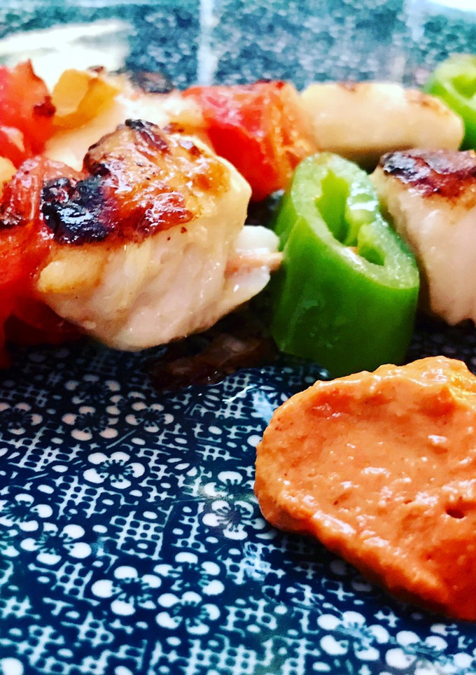 Una foto de Brochetas de rape y merluza con salsa romescu y cachelos al pimentón