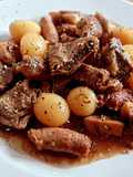 Lagarto y salchichas de cerdo con champiñones, patatas y alcachofas