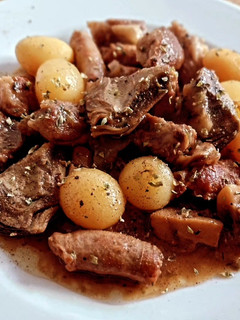 Una foto de Lagarto y salchichas de cerdo con champiñones, patatas y alcachofas