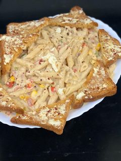 A picture of White sauce pasta with garlic butter and cheese bread.