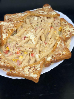 A picture of White sauce pasta with garlic butter and cheese bread.