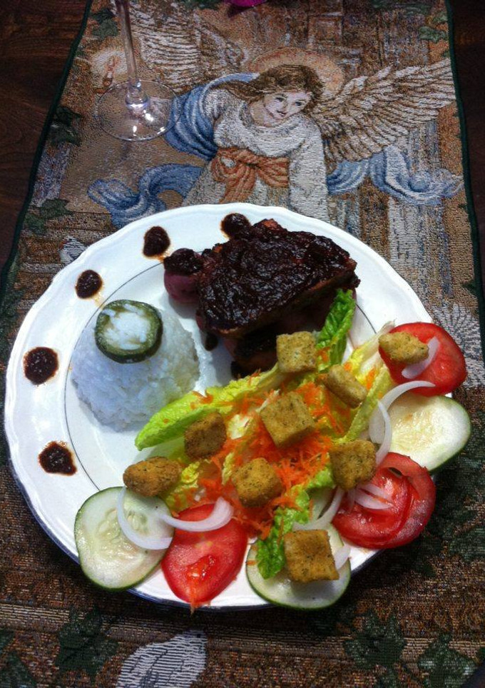 Una foto de Pierna adobada en cama de papas