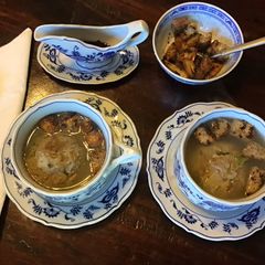 A picture of California Farm Chicken Liver Dumpling Matzo Soup with Croutons.
