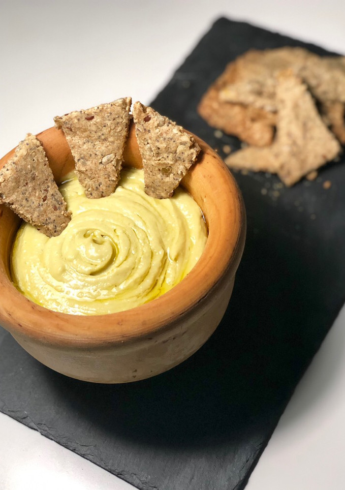 Una foto de Hummus de aguacate con crackers caseros