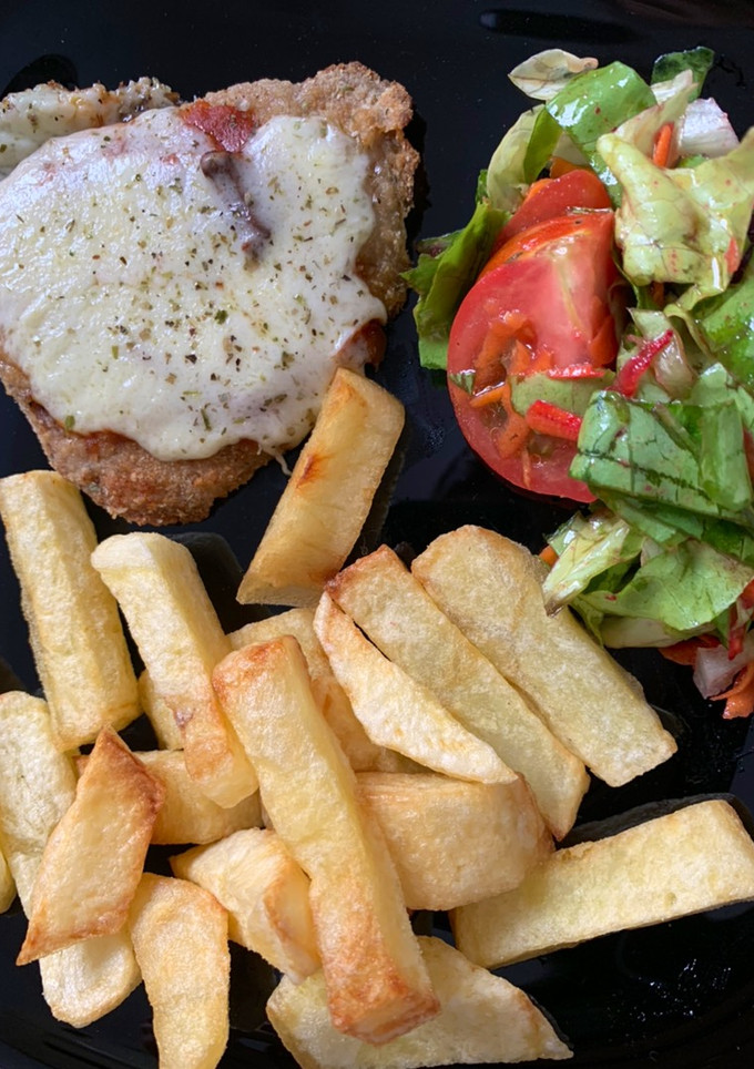 Una foto de Milanesa peceto napolitana con papas fritas