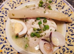 Foto principal de Merluza en salsa verde con espárragos, almejas y huevo duro