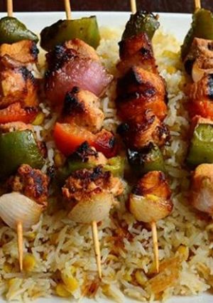 A picture of Chicken tikka sticks with chana daal garlic rice.