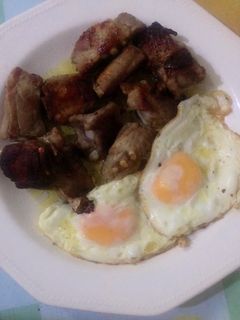 Una foto de Costilla con ajos y huevos fritos