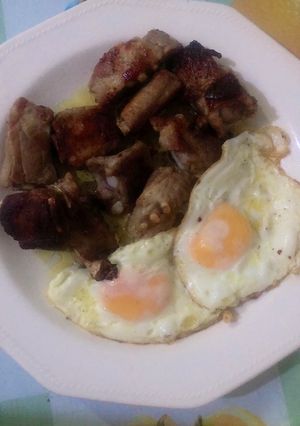 Una foto de Costilla con ajos y huevos fritos