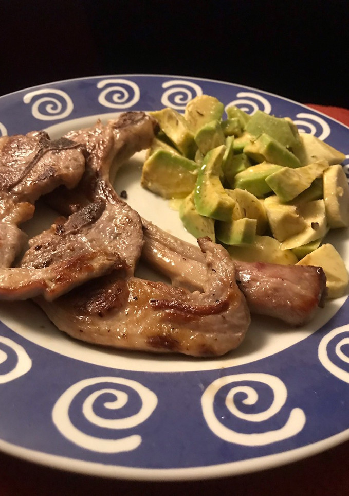 Una foto de Chuletitas de cordero y ensalada de aguacate