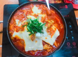 Hình của món Bánh tok xào gà cay phủ phô mai.