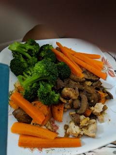 A picture of Steamed carrots broccoli over baked chicken in mushroom sauce.