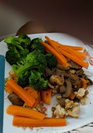 A picture of Steamed carrots broccoli over baked chicken in mushroom sauce.