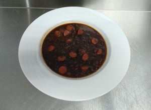 Una foto de Habichuelas negras con chistorras y pimientos ahumados