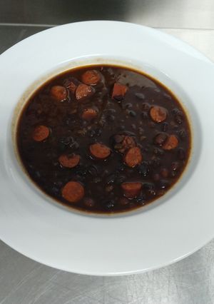 Una foto de Habichuelas negras con chistorras y pimientos ahumados