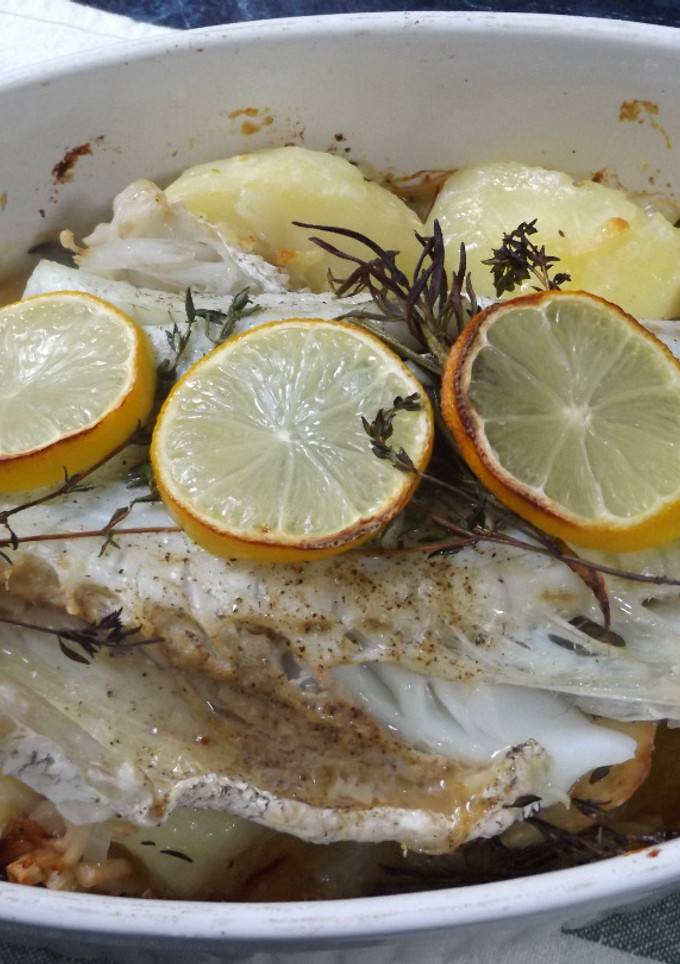Una foto de Corvina al horno con limón, patatas y cebolleta