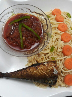 A picture of Spaghetti with tomato sauce and fried titus fish.
