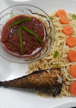 A picture of Spaghetti with tomato sauce and fried titus fish.