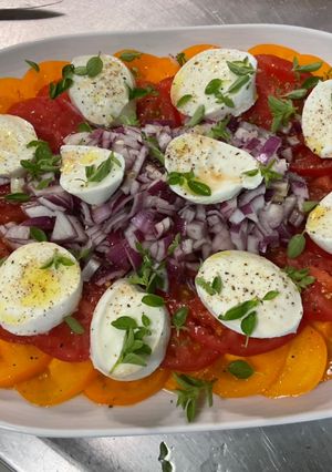 Une photo de Salade de tomates bicolores à l’oignon rouge et mozzarella