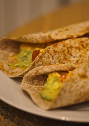 Una foto de 🌯Wrap de tortilla francesa, tomate, aguacate y salsa siracha