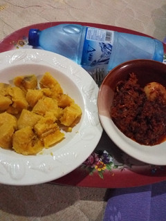 A picture of Boiled Ripe Plantain with Egg and Cow Skin (Kpomo) Sauce.
