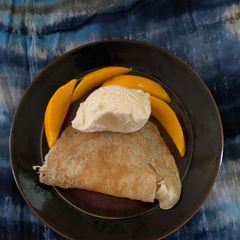 A picture of Crepes with ice cream and fruit.