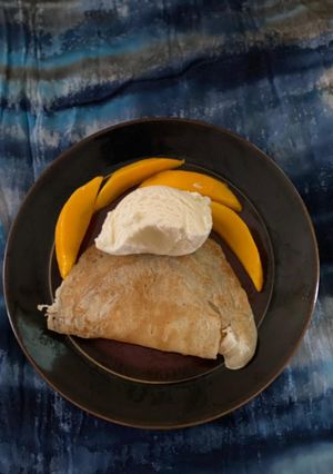 A picture of Crepes with ice cream and fruit.