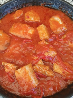 Una foto de Bonito con tomate y pimientos