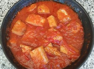 Una foto de Bonito con tomate y pimientos