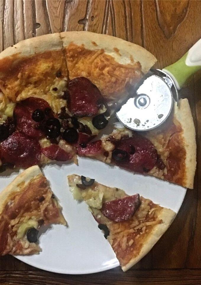 Una foto de Pizza de salami, tomates secos y alcachofa