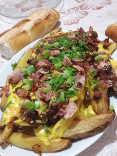 Una foto de Papas rústicas con cheddar y panceta