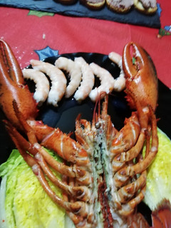 Una foto de Bogavante abierto con langostinos y cogollos de lechuga abiertos