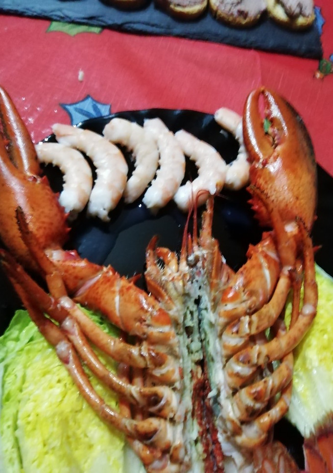 Una foto de Bogavante abierto con langostinos y cogollos de lechuga abiertos