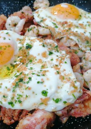 Una foto de Huevos rotos con pota y gambas