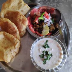A picture of Masala Puri cucumber raita and chole.
