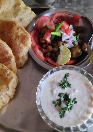A picture of Masala Puri cucumber raita and chole.